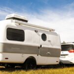 A top-rated travel trailer parked in a scenic outdoor setting, showcasing its modern design and features, perfect for RV enthusiasts seeking adventure and comfort