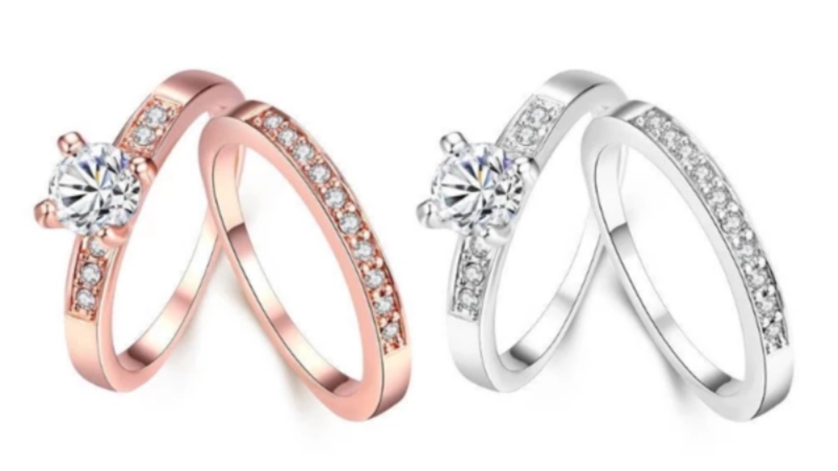 Two sets of engagement or wedding rings on a white background: one in rose gold and one in silver, each featuring a solitaire ring with a clear stone and a matching band with smaller accent stones.