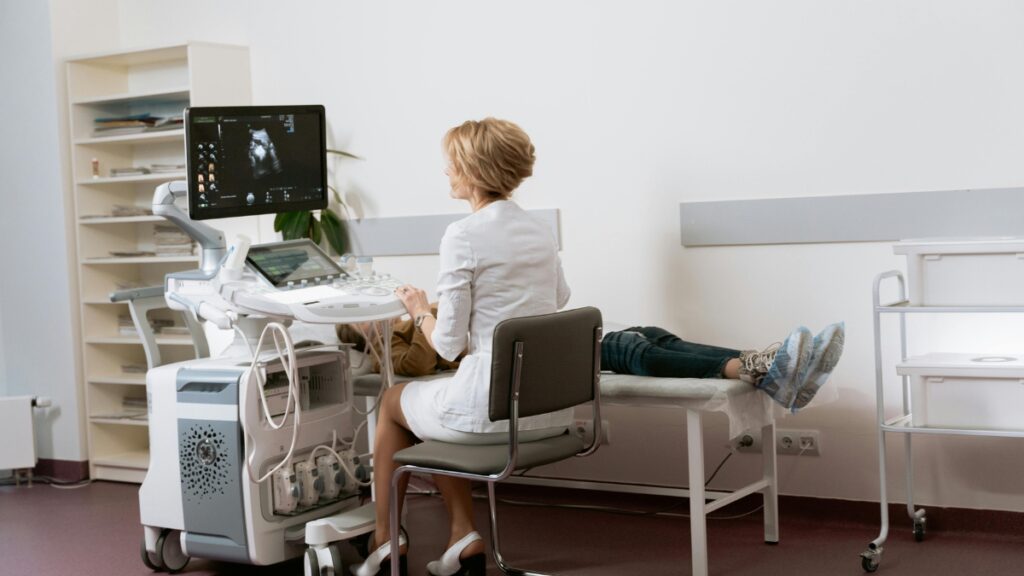 The Role of New Century Health in Modern Healthcare Medical professional performing an ultrasound examination on a patient in a clean, modern clinic, showcasing New Century Health technology and patient care