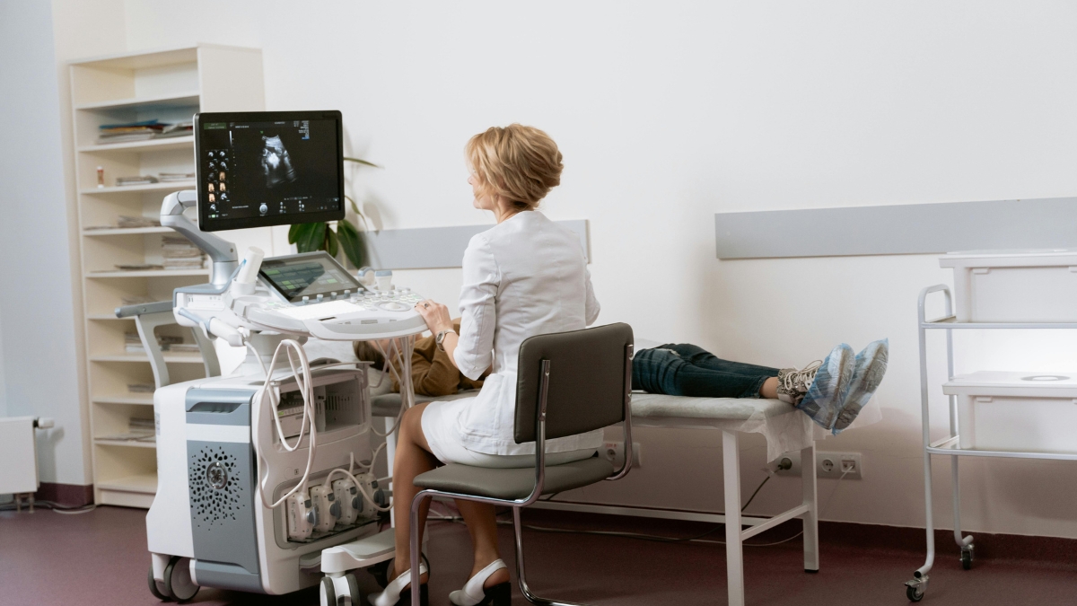 Medical professional performing an ultrasound examination on a patient in a clean, modern clinic, showcasing New Century Health technology and patient care